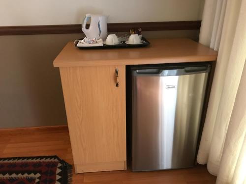 a small kitchen with a stainless steel refrigerator under a counter at De Oude Herberg in Centurion