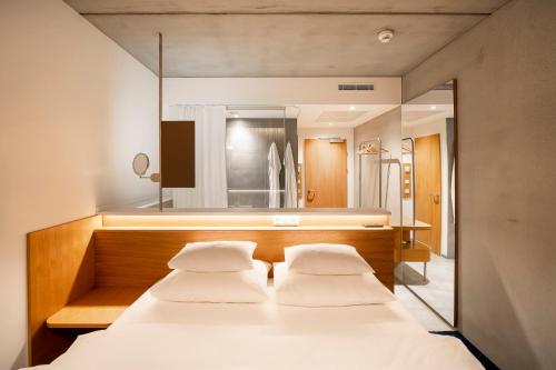 a bedroom with two beds and a mirror at FIRMAMENT Hotel in Feldkirch