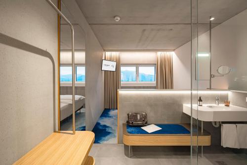un piccolo bagno con lavandino e specchio di FIRMAMENT Hotel a Feldkirch