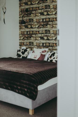 a bed in a room with a brick wall at Wilczarz in Duszniki Zdrój