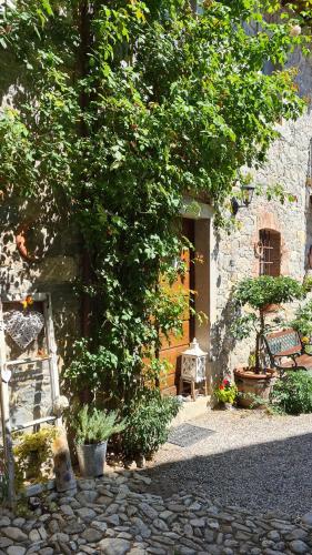 a tree in front of a building with a door at Affittacamere Valnascosta in Faedis