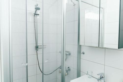 ハーネンクレー・ボックスヴィーゼにあるHaus Vier Jahreszeiten am See Apartment am Kranichseeのバスルーム(シャワー、洗面台、鏡付)