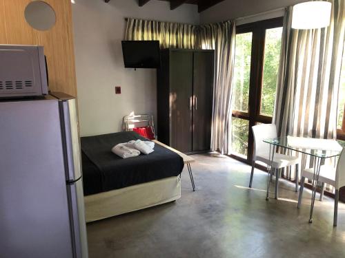 a room with a bed and a refrigerator and a table at Aguamansa in Las Gaviotas