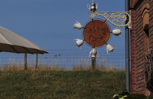 a sign on the side of a building with a fence at Landlust Unser L ieblingscafe in Xanten
