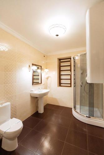 a bathroom with a toilet and a sink and a shower at GasthauS & SPA in Bukovel