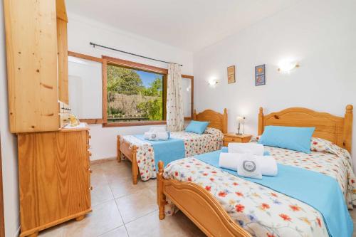 a bedroom with two beds and a window at Villa El Mal Pas / Can Seguinet in Alcudia
