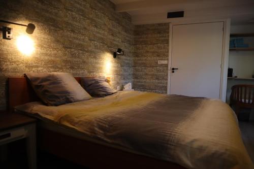 a bedroom with a bed with a brick wall at bio B&B boïzca in Exmorra