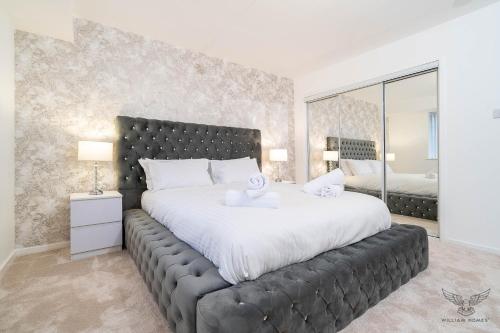 a bedroom with a large bed and a large mirror at WILLIAM HOMES - COOMBE ABBEY, Free Parking, King BED, NETFLIX & Pool Table in Coventry