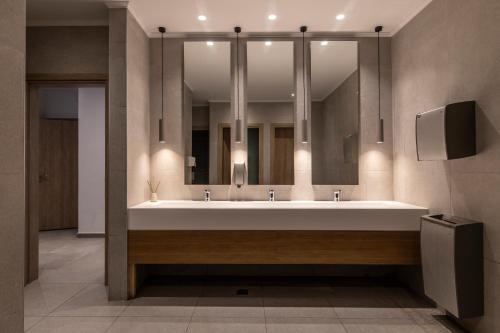 a bathroom with a sink and a large mirror at Eden Roc Resort - All Inclusive in Kallithea Rhodes