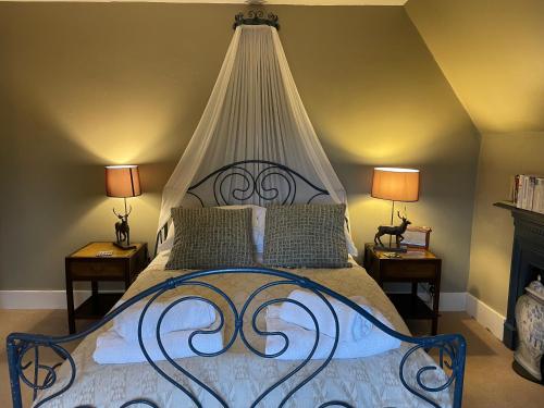 a bedroom with a large bed with a canopy at Ellesmere House in Castle Cary