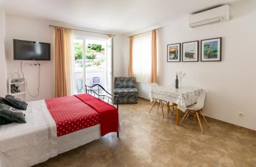 a bedroom with a bed and a table and a television at Apartments Veronika in Pag