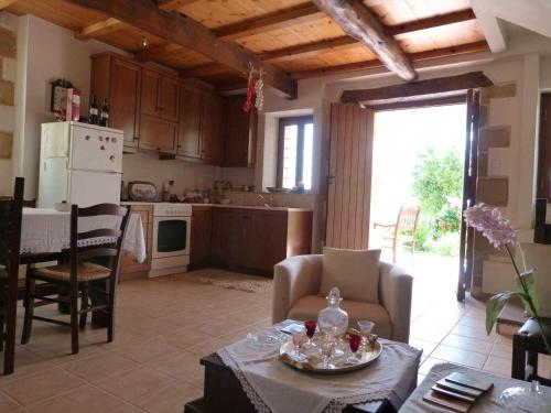 cocina y sala de estar con mesa y sillas en The Garden Villas, en Máleme