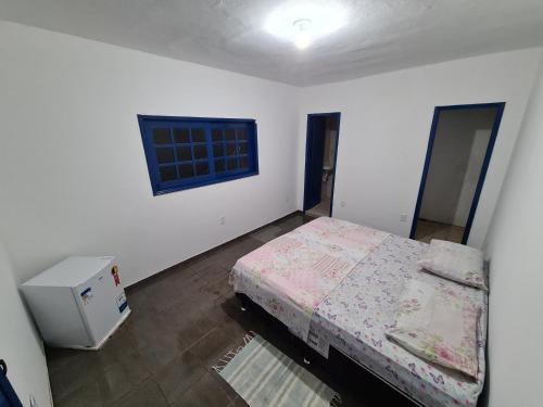 a small bedroom with a bed and a window at Santorini Flats in Arraial do Cabo
