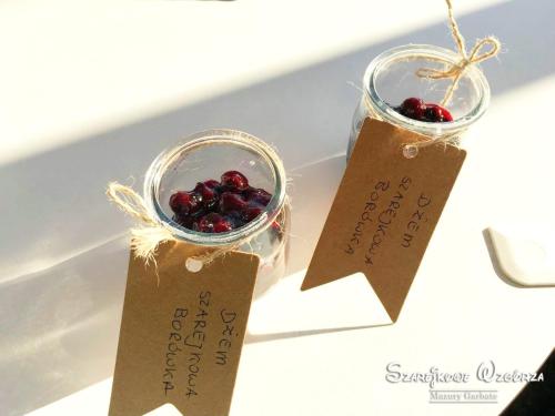 two glass jars filled with cherries sitting on a table at Szarejkowe Wzgórza in Szarejki