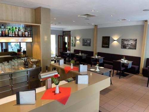 um restaurante com um bar e mesas e cadeiras em AZIMUT Hotel Nuremberg em Nurembergue