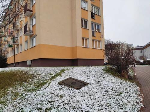 a building with a vent in the snow in front of a building at Mieszkanie M3 in Szczytno