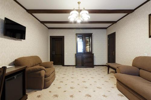 a living room with a couch and chairs and a television at GasthauS & SPA in Bukovel