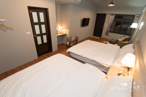a hotel room with two beds and a television at Bi La Homestay in Luye