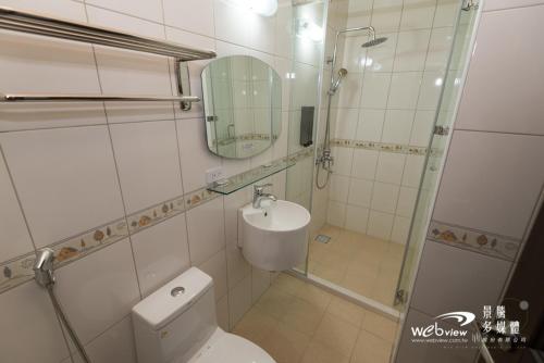 a bathroom with a toilet and a sink and a mirror at Bi La Homestay in Luye