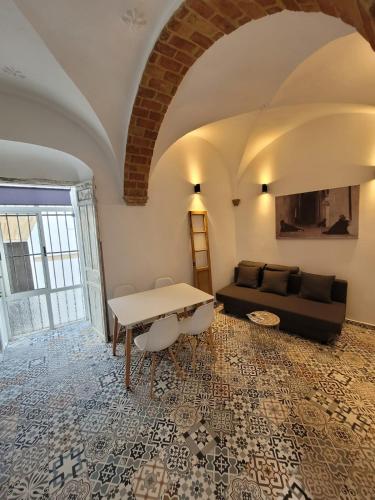 ein Wohnzimmer mit einem Sofa und einem Tisch in der Unterkunft Casa Cuna in Arcos de la Frontera