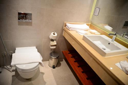 a bathroom with a sink and a toilet and a mirror at Marina Sharm Hotel in Sharm El Sheikh