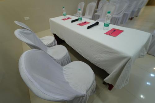 a white table with four chairs and a white table and chairsktop at Hotel Palmyra Grand Inn in Tirunelveli