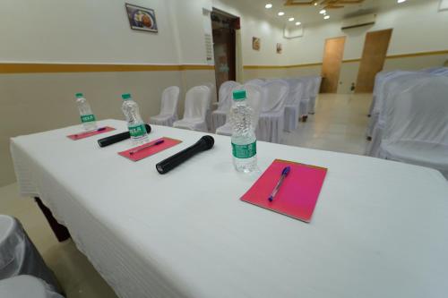a white table with two bottles of water and a pen at Hotel Palmyra Grand Inn in Tirunelveli