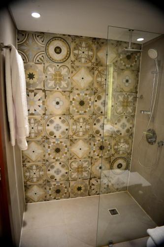 a bathroom with a shower with a tile wall at Marina Sharm Hotel in Sharm El Sheikh
