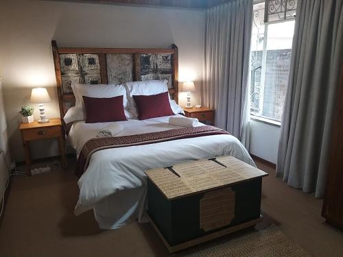 Kromdraai Guest Rooms في Kromdraai: غرفة نوم بسرير كبير ونافذة