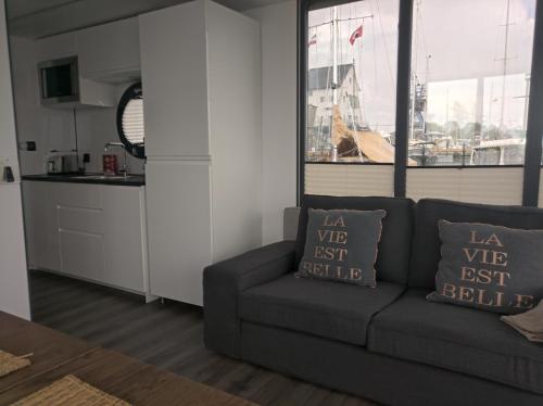 a living room with a couch and a kitchen at Ostsee Hausboot Schleswig Ostseeblick 1 in Schleswig