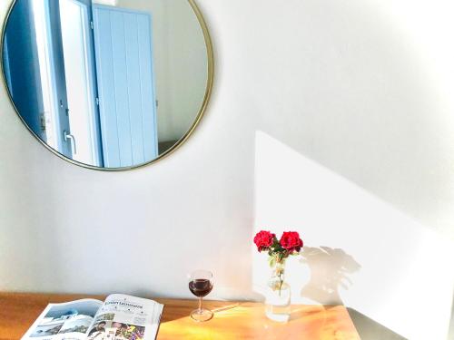 a table with a mirror and a vase with flowers at Villa Fotini in Firostefani