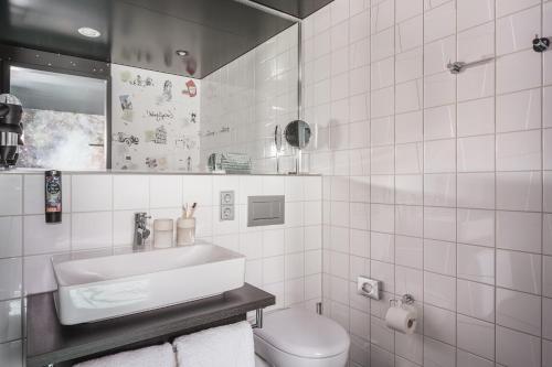 a white bathroom with a sink and a toilet at the niu Star - Apartments in Sindelfingen