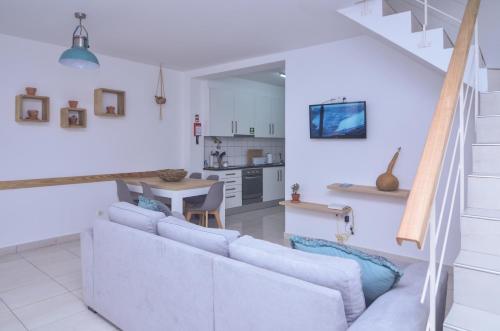 a living room with a couch and a kitchen at Sunrise House- 4 bedroom house with amazing sunrise over the sea 10 guests in Vila Franca do Campo