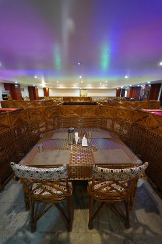 a dining room with a table and two chairs at Hotel Palmyra Grand Inn in Tirunelveli