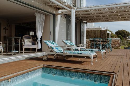 a patio with chairs and a pool on a deck at Nosterdomus in Paternoster
