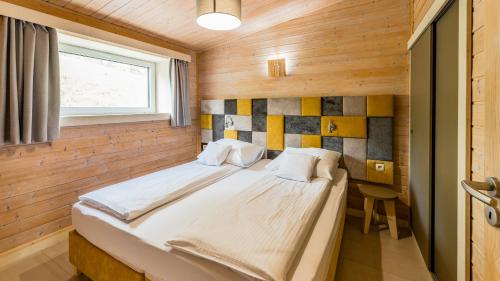 a bedroom with a large bed in a wooden room at Stranda in Giżycko