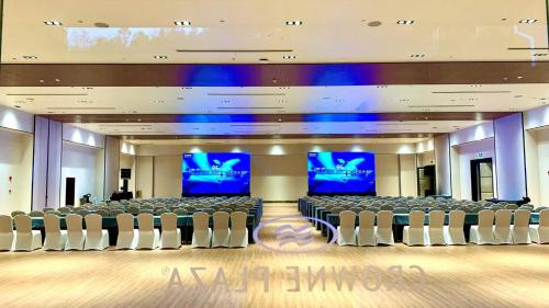 a large conference room with chairs and two screens at Howard Johnson Neodalle Resort Zhangjiajie in Zhangjiajie