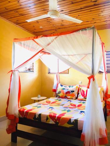 a bedroom with a bed with a canopy at Villa CHRIS, Calme et Sérénité in Andilana
