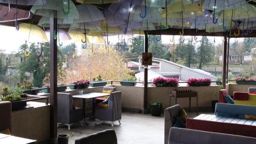 a restaurant with tables and chairs and umbrellas at Tskaltubo Hotel Terrace in Tskaltubo