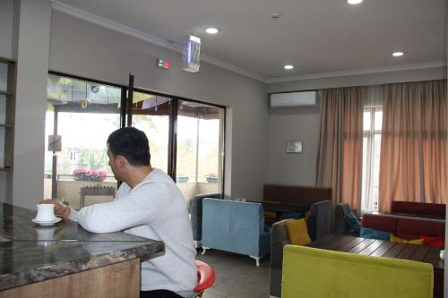 a man standing at a bar with a cup of coffee at Tskaltubo Hotel Terrace in Tskaltubo