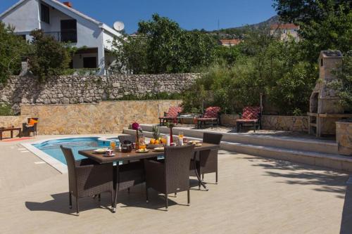 a table and chairs sitting on a patio next to a pool at Villa Avoca in Mlini