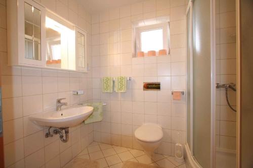 ein weißes Bad mit einem Waschbecken und einem WC in der Unterkunft Apartment Soline 2 in Soline