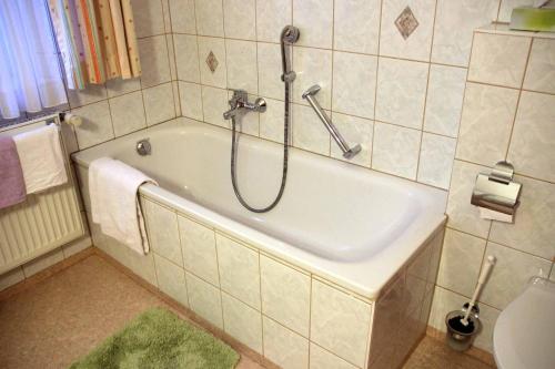 a bathroom with a bath tub with a shower at Hotel Gasthof Zum weissen Lamm in Hohenberg an der Eger
