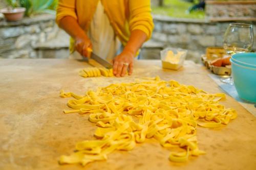 a person cutting up pasta on a cutting board at Podere Campriano Winery Adult only in Greve in Chianti