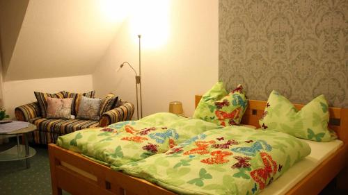 a bedroom with a bed and a couch at Hotel Gasthof Zum weissen Lamm in Hohenberg an der Eger