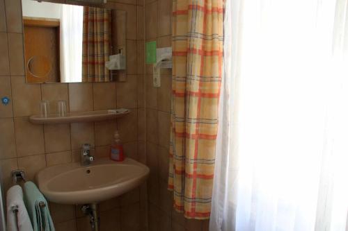 a bathroom with a sink and a shower curtain at Hotel Gasthof Zum weissen Lamm in Hohenberg an der Eger