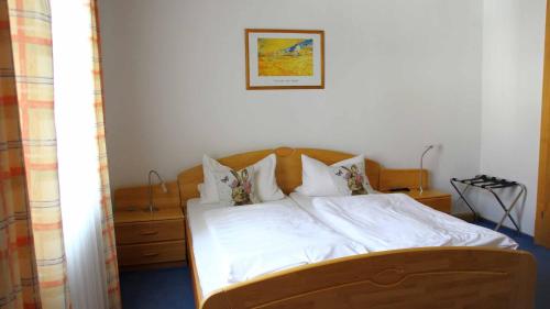 a bed with white sheets and pillows in a bedroom at Hotel Gasthof Zum weissen Lamm in Hohenberg an der Eger