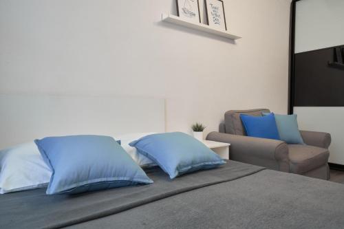 トムスクにある"GOOD NIGHT" on Kirova 34のベッドルーム1室(青い枕と椅子付きのベッド1台付)