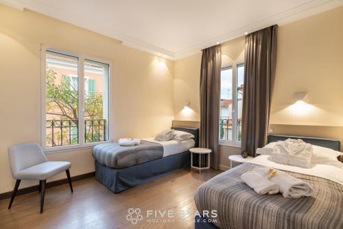 a hotel room with two beds and a chair at Villa Artemys - Five Stars Holiday House in Saint-Jean-Cap-Ferrat