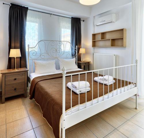 a bedroom with a bed with a white bed frame at Botanica Villas & Apartments in Neos Marmaras